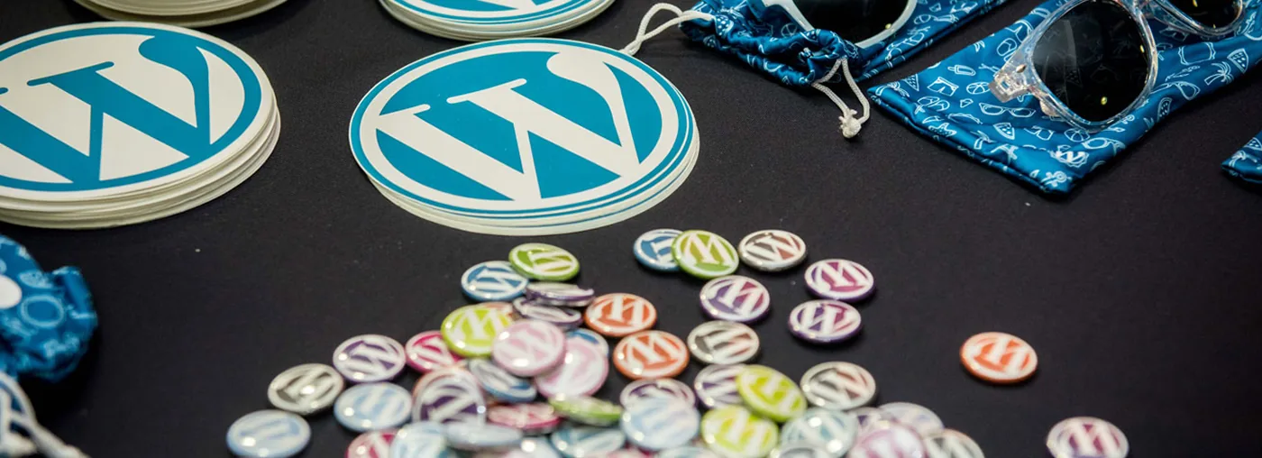 Mesa com diversos brindes temáticos com logo do WordPress